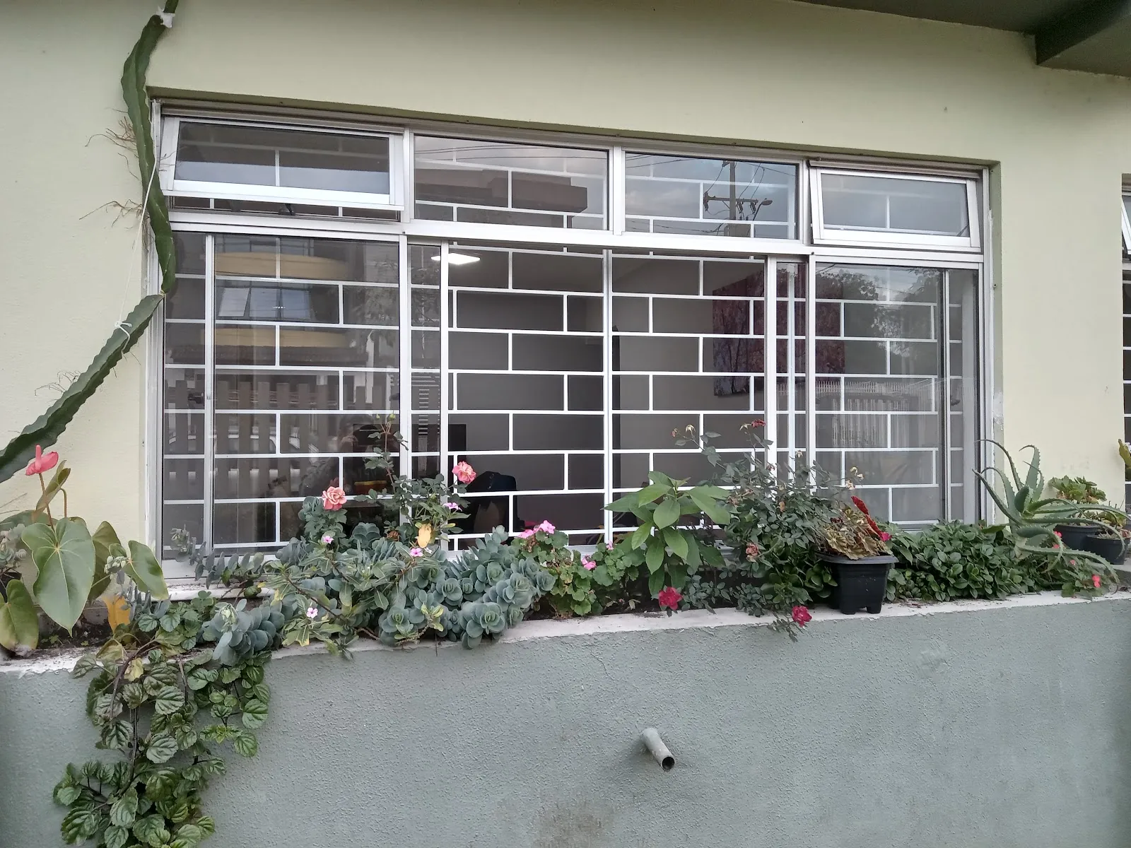 Grade de janela branca instalada em fachada de casa