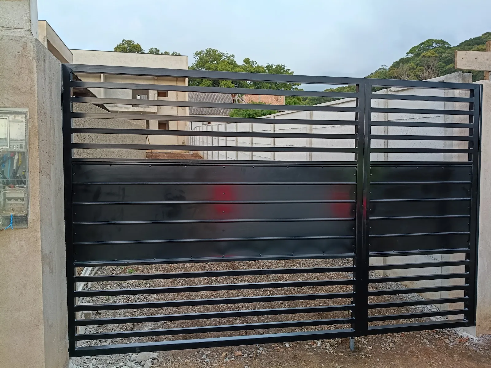 Portão metálico preto com lâminas horizontais feito pela Serralheria JMP